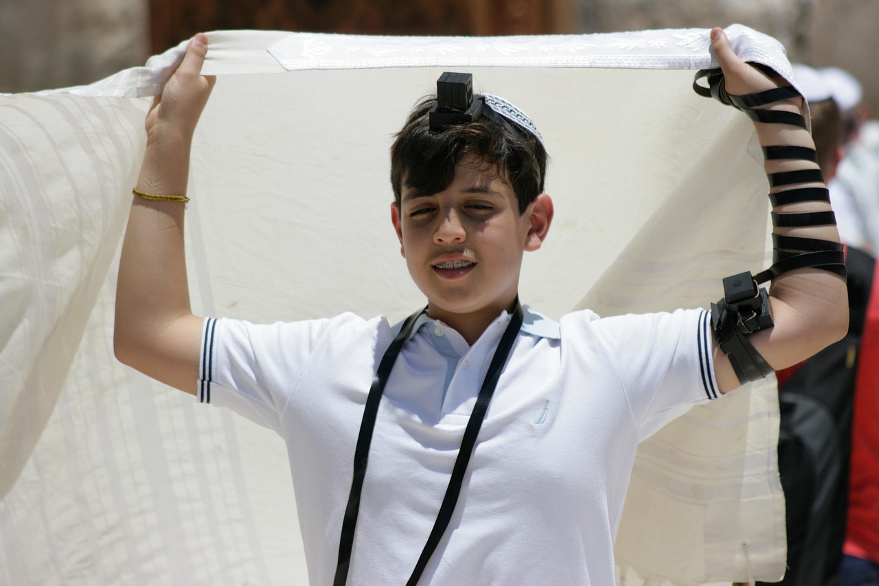 Jewish boy celebrating his bar mitzvah wrapped in tefillin.